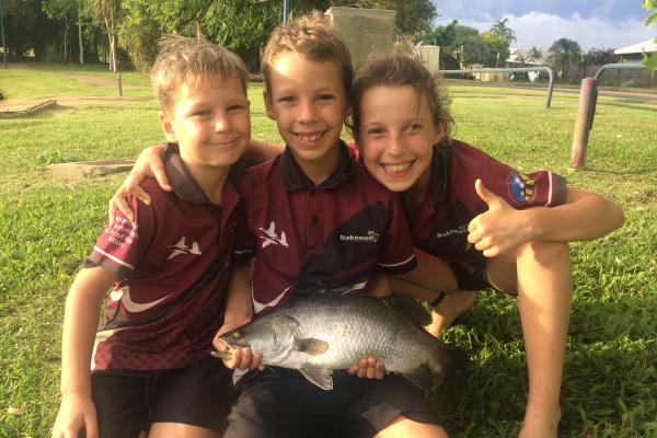 three children holding barra