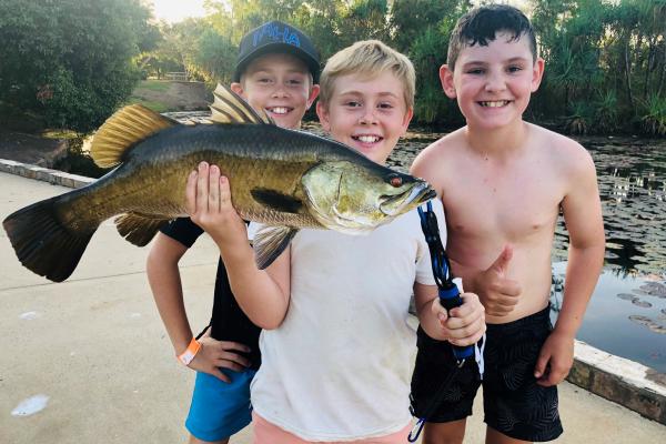 three kids with barra catch