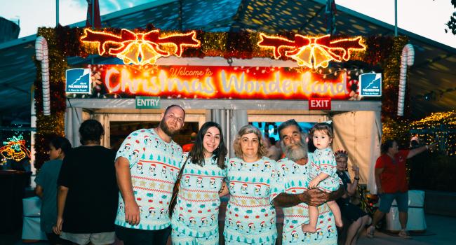 Image: family standing infront of Christmas Wonderland entry 